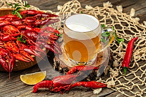 Boiled crayfish with beer on a wooden background. Lobster closeup