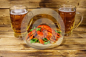 Boiled crayfish and two mugs of beer on wooden table