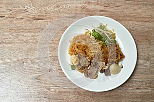 Boiled dry vermicelli thin rice noodles topping slice braised pork and meatball dressing sweet black soybean sauce on plate