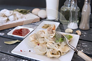 boiled dumplings, fork, wooden, grey background