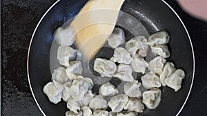 Boiled dumplings are fried in a hot pan