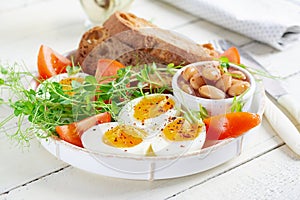 Boiled egg, beans, toast and green herbs