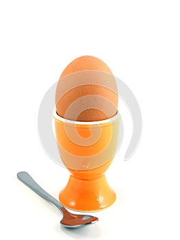 A boiled egg in cup with spoon