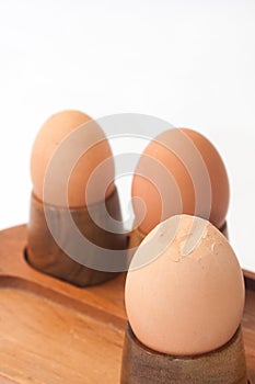 Boiled eggs in egg holder with cracked egg