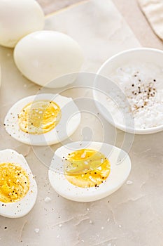 Boiled eggs peeled and cut in half with salt and pepper