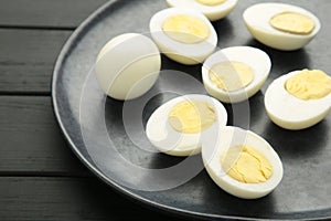 Boiled eggs on plate on black wooden background