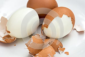 Boiled eggs on plate with broken eggshell
