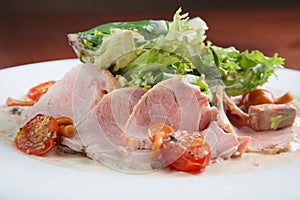 Boiled eggs with smoked ham and vegetables on white plate