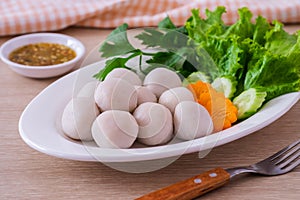 Boiled fish balls and vegetable on white plate