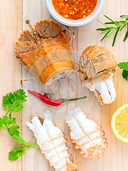 Boiled Flathead lobster, Lobster Moreton Bay bug, Oriental flathead lobster with herbs and spices sauce on wooden background.