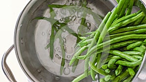 Boiled green beans close-up. French sting beans, Haricots Verts, in a pot with boiling water, close up cooking process photo