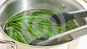 Boiled green beans close-up. French sting beans, Haricots Verts, in a pot with boiling water photo