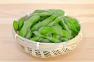 Boiled green soybeans in a small bamboo basket