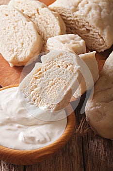 Boiled knedliks with sour cream macro on the table. vertical