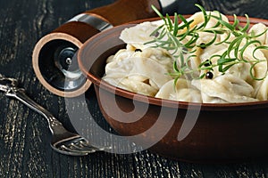 Boiled meat dumplings in big dish with cream