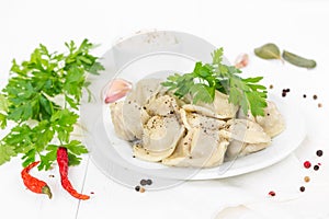 Boiled meat dumplings with sprig of parsley in white plate