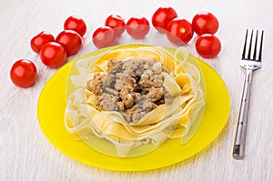 Boiled noodles with fried mincemeat in plate, tomatoes cherry, f