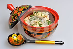 Boiled pelmeni in khokhloma painted russian wooden dishes with spoon