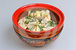 Boiled pelmeni in traditional painted russian wood