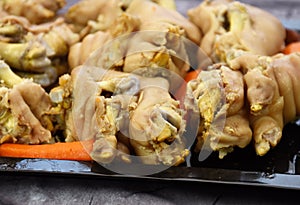 Boiled pork legs on a black pan. boiled pig`s feet.