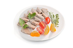 Boiled pork tongue with tomatoes and herbs isolated on white background. Side view, close up