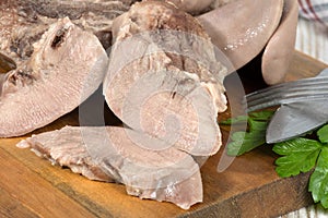 Boiled pork tongues are on cutting board