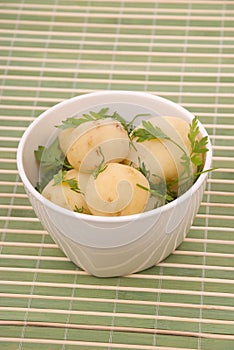 Boiled potatoes with parsley on a bamboo