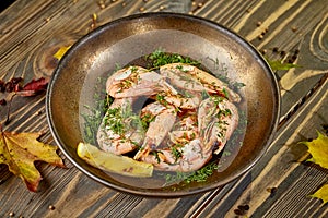 Boiled prawns with lemon and dill are on a plate