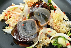 Boiled preserved egg half cut with white mushroom Thai salad on plate