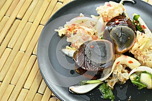 Boiled preserved egg half cut with white mushroom Thai salad on plate