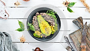 Boiled quinoa with avocado and vegetables.