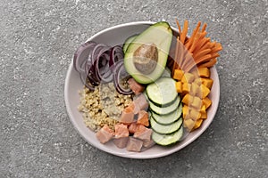 Boiled Quinoa with salmon and vegetables in a bowl on the table, a healthy lunch,