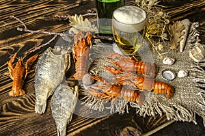 Boiled red crayfish with dried salted fish,glass with beer and a bottle of beer