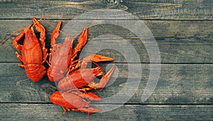 Boiled red crayfish on a wooden table surface, top view. Snack for beer