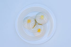 Boiled rice with cheese on white plate on white background photo