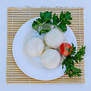 Boiled rice with cheese on white plate on white background photo