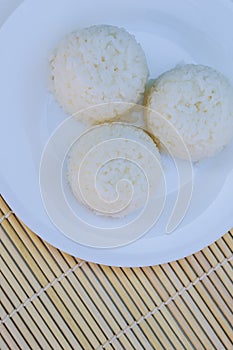 Boiled rice with cheese on white plate on white background photo