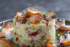 Boiled rice with fried red peppers, carrots and onions, close up