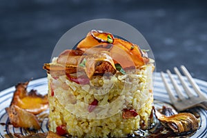 Boiled rice with fried red peppers, carrots and onions, close up