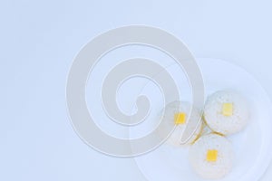 Boiled rice with cheese on white plate on white background photo