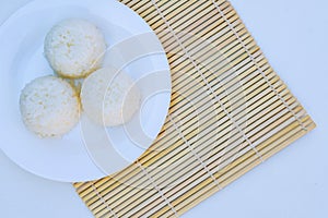 Boiled rice with cheese on white plate on white background photo