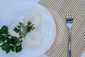 Boiled rice with cheese on white plate on white background photo