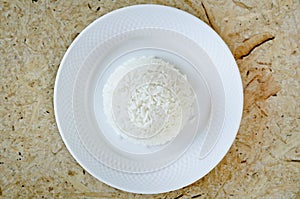 Boiled rice on a white plate on wood background photo