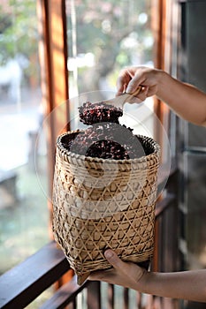 Boiled riceberry rice on wood basket with spoon in close up