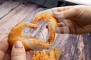 Boiled shrimp on the background of a wooden table form the shape of a heart and lean against each other