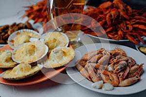 Boiled shrimps, scallops with cheese, boiled crayfish and beer for oktoberfest