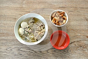 boiled slice and chop pork with meatball in clear soup on bowl eat couple baking pork skin cracker in cup