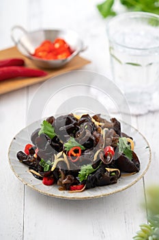 Boiled small black fungus cold dish on white table background