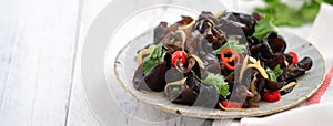 Boiled small black fungus cold dish on white table background