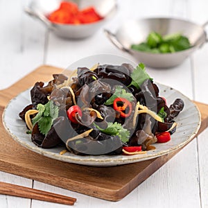 Boiled small black fungus cold dish on white table background